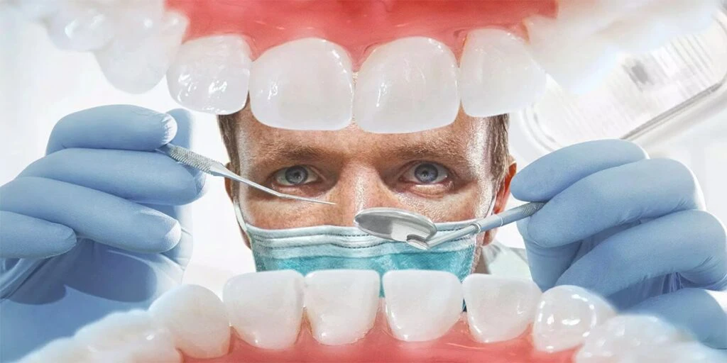 ابزار دندانپزشکی کنار مدل دندان و لثه